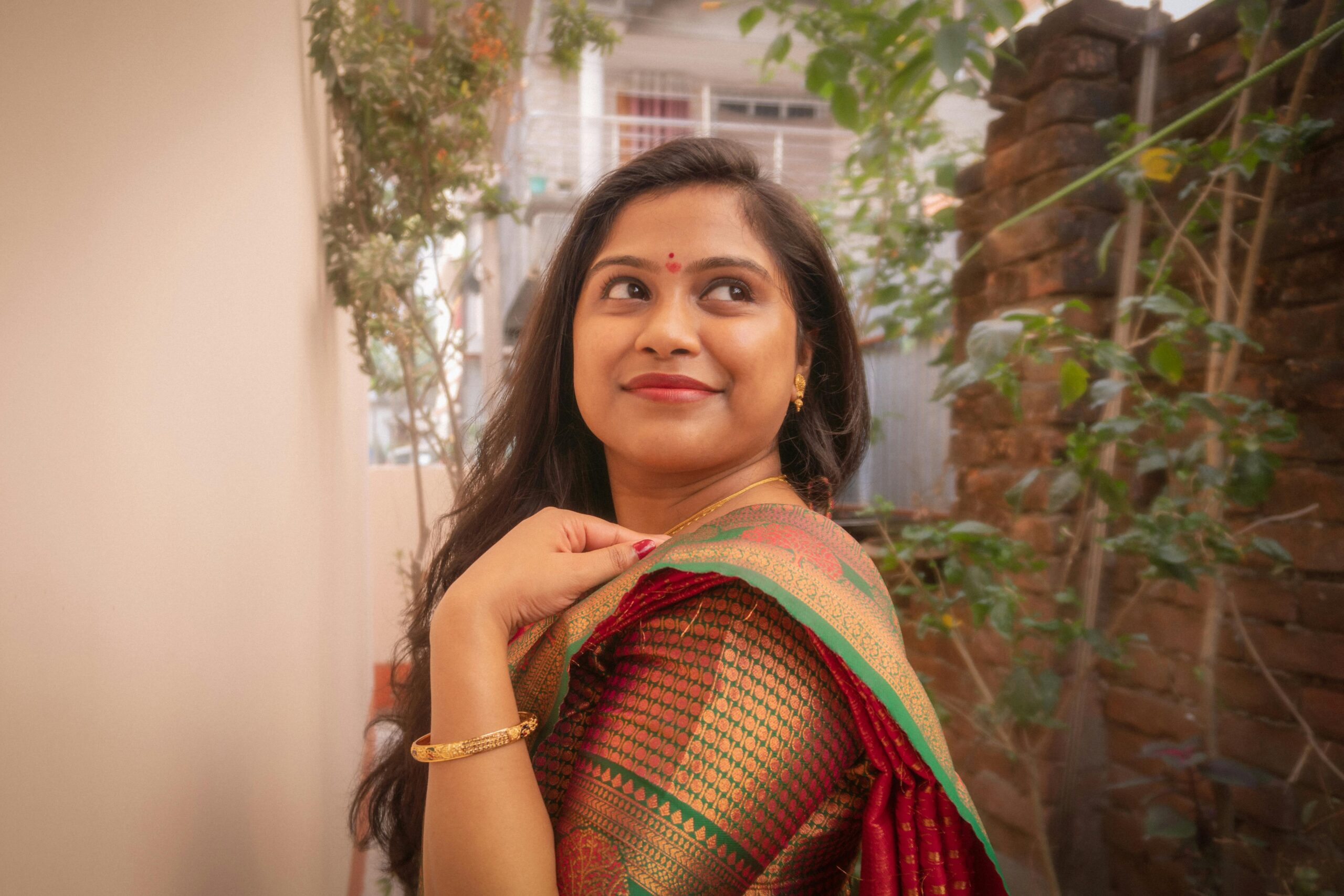 Beautiful woman smiling in a traditional Indian saree, embracing elegance in an outdoor setting.